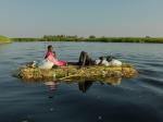 A man and wife float down the White Nile on a grass mound. They hope to reach New Fangak with the current of the river.